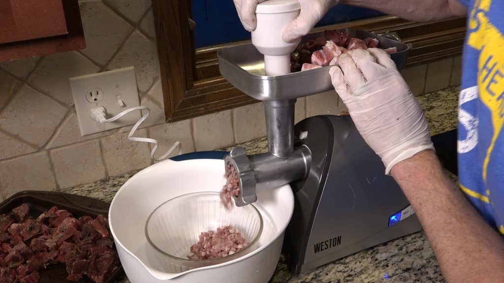 Grinding meat for wild rice venison bratwurst by Modern Carnivore